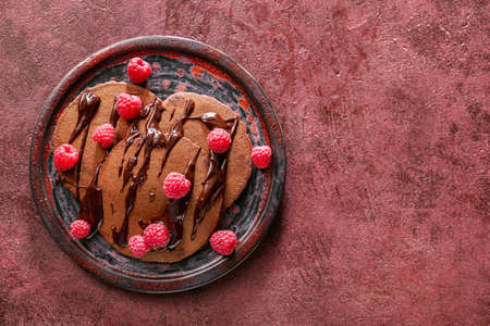 Plate with delicious chocolate pancakes on color backgroundの写真素材