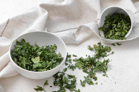 Bowls with dry parsley on white backgroundの写真素材