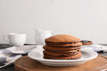 Plate with delicious chocolate pancakes on table