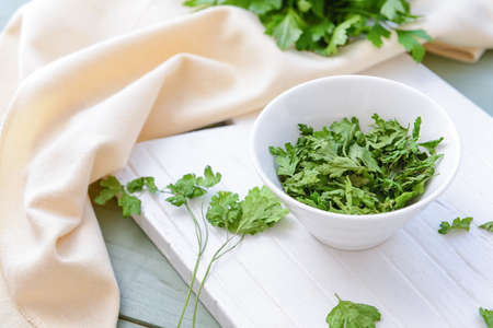 Bowl with dry parsley on tableの写真素材