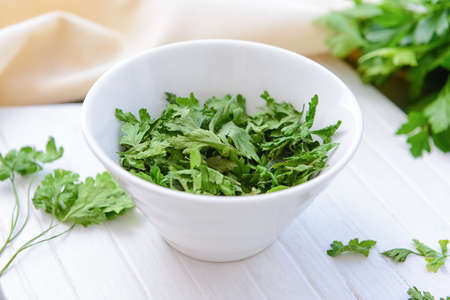 Bowl with dry parsley on tableの写真素材