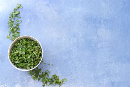 Bowl with dry parsley on color backgroundの写真素材