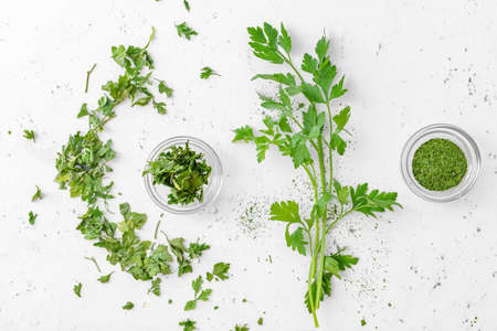 Healthy fresh and dry parsley on white background