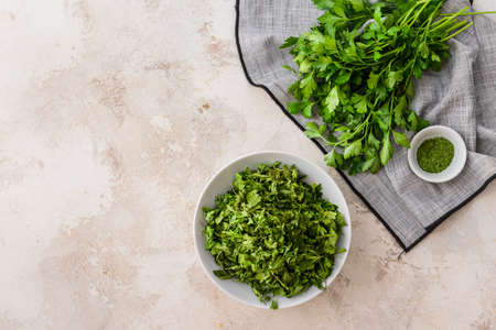 Bowl with dry and fresh parsley on light backgroundの写真素材
