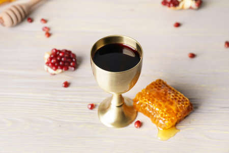 Sacramental goblet with wine, honey and pomegranate on table. Rosh Hashanah (Jewish New Year) celebrationの写真素材