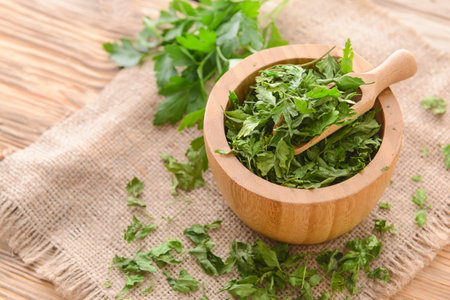 Bowl with dry parsley on tableの写真素材