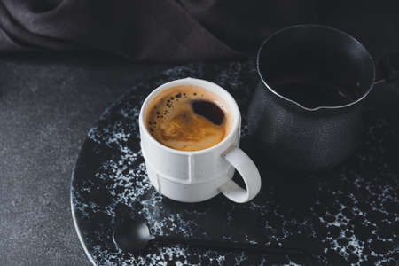Cup of hot coffee with pot on dark backgroundの写真素材
