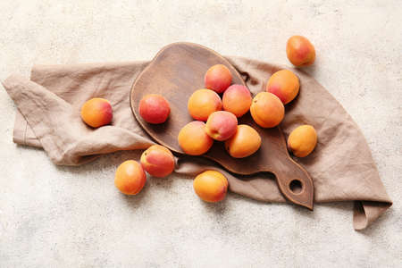 Board with tasty ripe apricots on gray backgroundの写真素材