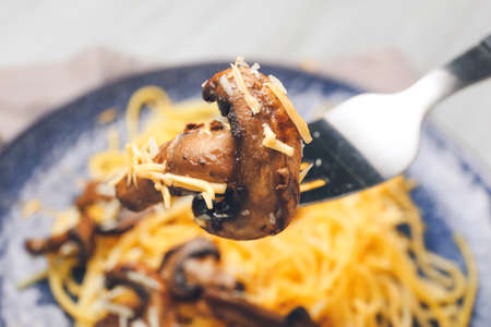 Eating of tasty pasta with mushrooms from plate, closeupの写真素材