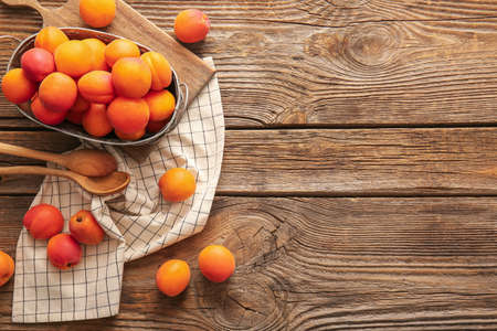 Basket with tasty ripe apricots on tableの写真素材