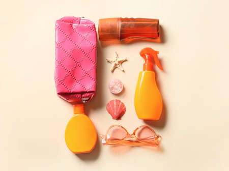 Bag with sunscreen cream and sunglasses on color backgroundの写真素材