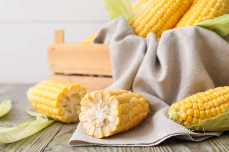 Box with fresh corn cobs on tableの写真素材
