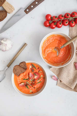 Bowls of tasty tomato cream soup on light backgroundの写真素材