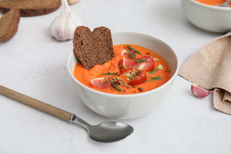 Bowl of tasty tomato cream soup on tableの写真素材