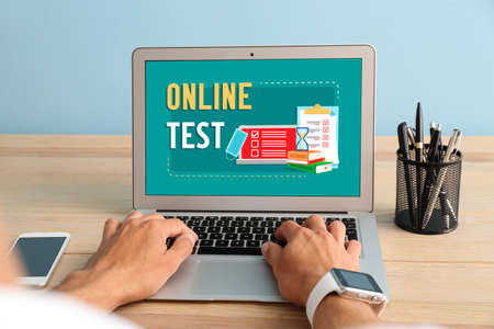 Man with laptop passing exams online at homeの写真素材