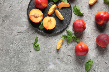 Plate with sweet ripe peaches on tableの写真素材