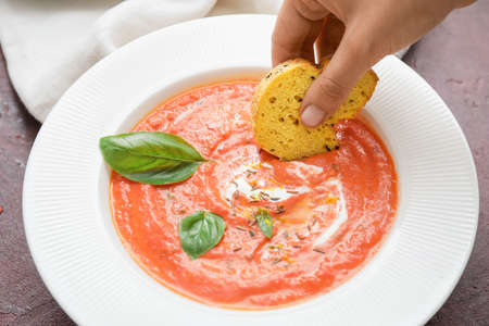 Woman eating tomato cream soupの写真素材