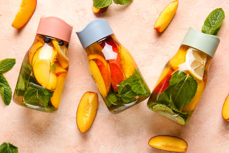 Peach cocktail in glass bottles on tableの写真素材