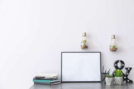 Table with floral decor, stationery and photo frame in roomの写真素材