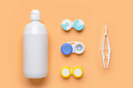 Containers with contact lenses, solution and tweezers on color backgroundの写真素材