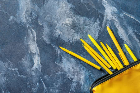 Case with markers and pens on grunge background