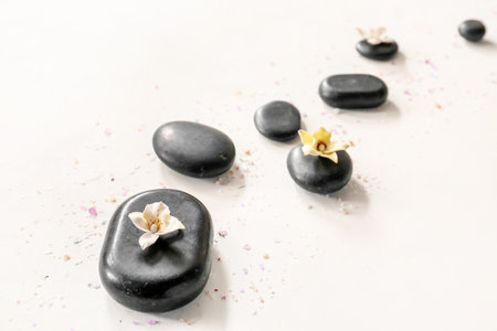 Spa stones and flowers on light background. Zen concept