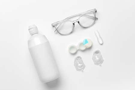 Container with contact lenses, solution, tweezers and eyeglasses on white backgroundの写真素材