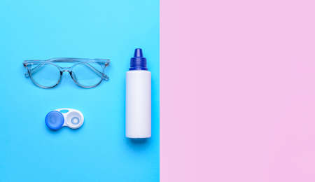 Container with contact lenses, solution and eyeglasses on color backgroundの写真素材