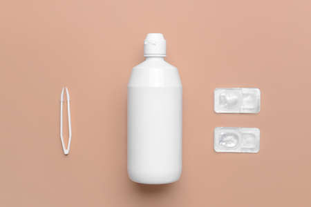 Contact lenses, solution and tweezers on color backgroundの写真素材