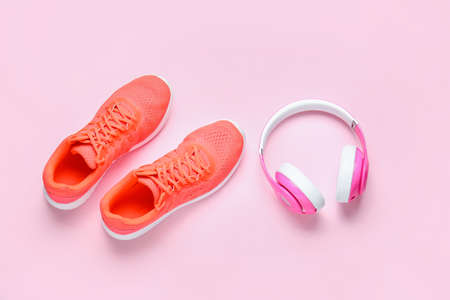 Sportive shoes and headphones on color backgroundの写真素材