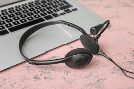 Headset with laptop on color backgroundの写真素材