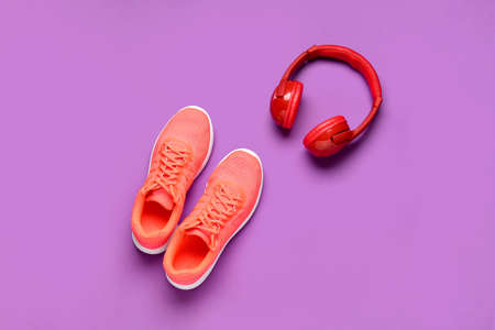 Sportive shoes and headphones on color backgroundの写真素材