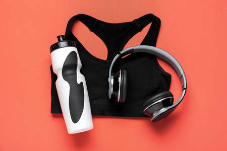 Sportive clothes, bottle of water and headphones on color backgroundの写真素材