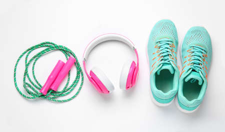 Sportive shoes, jumping rope and headphones on white backgroundの写真素材