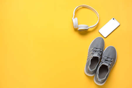 Sportive shoes, mobile phone and headphones on color backgroundの写真素材