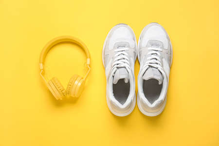 Sportive shoes and headphones on color backgroundの写真素材