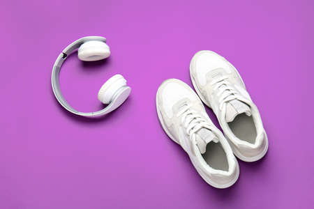 Sportive shoes and headphones on color backgroundの写真素材