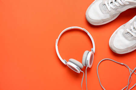 Sportive shoes and headphones on color backgroundの写真素材