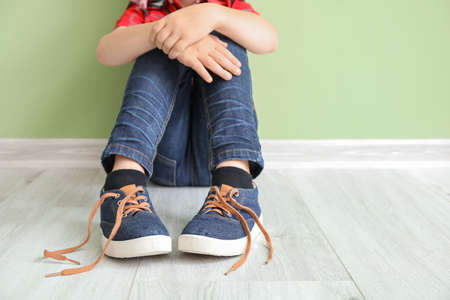 Little boy with autistic disorder sitting near color wallの写真素材