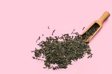 Scoop with dry green tea on color backgroundの写真素材
