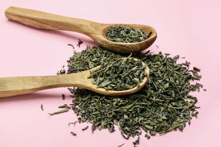 Spoons with dry green tea on color backgroundの写真素材