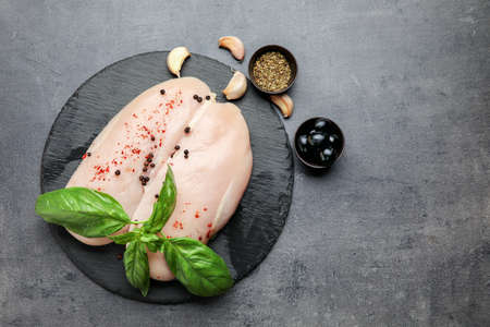 Board with raw chicken fillet on dark backgroundの写真素材
