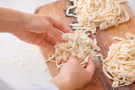 Woman making raw pasta in kitchen, closeupの写真素材