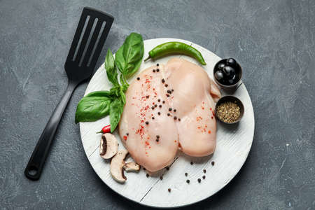 Board with raw chicken fillet on dark backgroundの写真素材