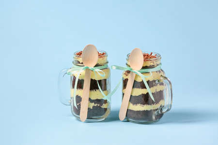 Delicious cupcakes in jars on color backgroundの写真素材