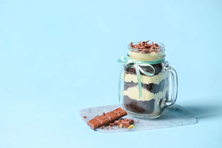 Delicious cupcake in jar on color backgroundの写真素材