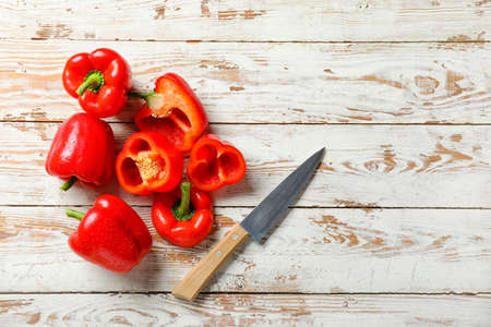 Red bell pepper and knife on wooden backgroundの写真素材