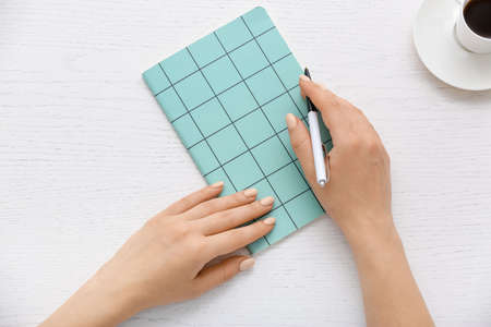 Woman with notebook and pen on light backgroundの写真素材