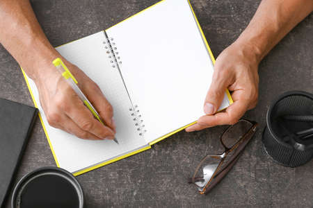 Man writing in notebook with penの写真素材