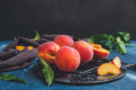 Board with ripe peaches on tableの写真素材